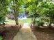 Landscaped backyard with a stone path leading to a cozy patio and fire pit area at 155 Marlow Dr, Woodstock, GA 30188