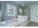 Bright bathroom featuring soaking tub and a glass-enclosed shower at 155 Marlow Dr, Woodstock, GA 30188