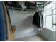 Walk-in closet with shelving and clothes hanging, brightened by natural light from the backyard window at 155 Marlow Dr, Woodstock, GA 30188