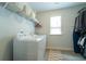 Bright laundry room features a washer, dryer, storage, and a window for natural light at 155 Marlow Dr, Woodstock, GA 30188