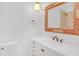 Bathroom featuring marble countertop with white cabinets below and a framed mirror at 1559 Norwood Dr, Lilburn, GA 30047