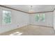 Bedroom with neutral colored carpet and paint, with a chandelier and natural lighting at 1559 Norwood Dr, Lilburn, GA 30047