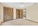 Neutral bedroom featuring shuttered closet doors, ceiling fan, and doorway to the landing at 1559 Norwood Dr, Lilburn, GA 30047