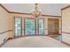 Formal dining room with a chandelier, large windows, custom molding, and carpeted floors at 1559 Norwood Dr, Lilburn, GA 30047