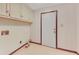 Functional laundry room featuring overhead cabinets and a door to the exterior at 1559 Norwood Dr, Lilburn, GA 30047