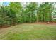 Large backyard featuring a well-maintained lawn surrounded by mature trees, providing privacy at 529 Wintergreen Way, Canton, GA 30115