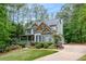 Two-story home with a stone accent wall, lush landscaping, and a long driveway at 529 Wintergreen Way, Canton, GA 30115