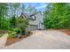 Side exterior view of a two-story home showing a garage and a long driveway at 529 Wintergreen Way, Canton, GA 30115