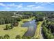 Scenic aerial view of the golf course with a tranquil lake featuring a fountain at 146 Cedar Woods Trl, Canton, GA 30114