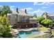 Large backyard featuring a pool, patio, spiral staircase, outdoor fireplace, and lush landscaping at 146 Cedar Woods Trl, Canton, GA 30114