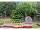 The community entrance sign beautifully landscaped with flowers and greenery at 146 Cedar Woods Trl, Canton, GA 30114