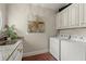 Functional laundry room featuring granite countertop sink, white cabinets, and matching white washer and dryer at 146 Cedar Woods Trl, Canton, GA 30114