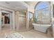 Bright main bathroom with a large arched window above the soaking tub and tiled walk-in shower at 146 Cedar Woods Trl, Canton, GA 30114