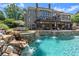 Backyard pool area featuring a beautiful rock waterfall, an elevated lounge area, and lush landscaping at 146 Cedar Woods Trl, Canton, GA 30114