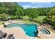 Aerial view of a backyard pool and hot tub with beautiful landscaping and a lush green golf course at 146 Cedar Woods Trl, Canton, GA 30114