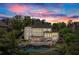 Beautiful backyard with swimming pool, spa, lounge area, and outdoor kitchen at dusk at 146 Cedar Woods Trl, Canton, GA 30114