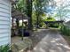 View of the backyard with a covered storage area, gravel space, and mature trees for privacy and shade at 212 South Se Ave, Marietta, GA 30060