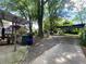 View of the backyard featuring a covered storage area and gravel space, complemented by mature trees for privacy and shade at 212 South Se Ave, Marietta, GA 30060