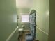A cozy bathroom features a toilet, window, shower curtain, green walls, and neutral flooring at 212 South Se Ave, Marietta, GA 30060