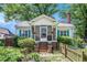 Charming home with a cozy screened front porch, brick steps, lush landscaping, and bright blue shutters at 212 South Se Ave, Marietta, GA 30060