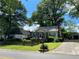 Inviting home featuring a well-kept lawn, a screened porch, and light-colored siding complemented by vibrant blue shutters at 212 South Se Ave, Marietta, GA 30060