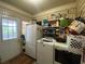 Functional laundry room with appliances and shelves for storage, next to an exterior door at 212 South Se Ave, Marietta, GA 30060