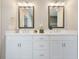 Bright bathroom featuring double sinks, white cabinetry, decorative mirrors and tile floors at 1436 Belmont Ave, Smyrna, GA 30080