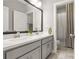 Bathroom with double sink, gray cabinets, a large mirror, and a shower with a curtain at 1436 Belmont Ave, Smyrna, GA 30080