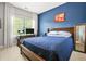 Bedroom featuring a blue accent wall, wooden furniture, and a window view at 1436 Belmont Ave, Smyrna, GA 30080
