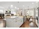 Open-concept kitchen featuring stainless appliances, granite counters, farmhouse sink, and adjacent living and dining areas at 1436 Belmont Ave, Smyrna, GA 30080
