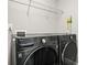 Contemporary laundry room with updated washer and dryer and overhead storage racks at 1436 Belmont Ave, Smyrna, GA 30080