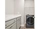 Well-organized laundry room featuring gray cabinets, counter space, patterned tile floor and a modern washer at 1436 Belmont Ave, Smyrna, GA 30080
