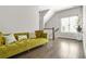Living room with a comfortable green sofa, hardwood floors, and natural light from the window at 1436 Belmont Ave, Smyrna, GA 30080