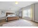 Bright main bedroom featuring a wood bed frame, neutral walls, and a light-colored rug on hardwood floor at 1436 Belmont Ave, Smyrna, GA 30080