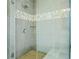 Elegant walk-in shower featuring glass door and decorative tile stripe at 1436 Belmont Ave, Smyrna, GA 30080