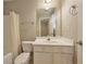 Standard bathroom with a white single sink vanity, toilet, framed mirror, and shower with curtain at 3094 Lauren Parc Rd, Decatur, GA 30032