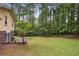 The back yard features a patio, grill and lots of grassy space surrounded by mature trees at 358 W West Wind Sw Dr, Lilburn, GA 30047