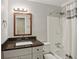 Well lit bathroom featuring a single sink vanity, brown countertop, shower and tub with striped curtain at 358 W West Wind Sw Dr, Lilburn, GA 30047