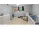 Bedroom with a crib, dresser, and rocking chair in soft pastel colors at 358 W West Wind Sw Dr, Lilburn, GA 30047