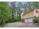 Long driveway leads to a two story home with a 2 car garage surrounded by mature trees at 358 W West Wind Sw Dr, Lilburn, GA 30047