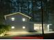 Modern home with sleek design, illuminated windows, and inviting landscape lighting at 358 W West Wind Sw Dr, Lilburn, GA 30047