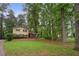 Traditional two-story home with brick and siding sits on a sprawling green lawn surrounded by tall trees at 358 W West Wind Sw Dr, Lilburn, GA 30047