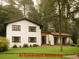 Classic two-story home with a white exterior, a well-manicured lawn, and natural accents at 358 W West Wind Sw Dr, Lilburn, GA 30047