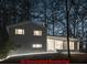 Modern home featuring large windows and a streamlined design, nestled within a wooded area at 358 W West Wind Sw Dr, Lilburn, GA 30047