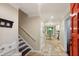 Hallway with tile flooring leads to the kitchen and dining nook beyond the open red front door at 358 W West Wind Sw Dr, Lilburn, GA 30047