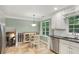 Bright kitchen features white cabinets, dark countertops, and a cozy breakfast nook with plenty of natural light at 358 W West Wind Sw Dr, Lilburn, GA 30047