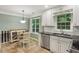 Bright kitchen features white cabinets, dark countertops, and a cozy breakfast nook with plenty of natural light at 358 W West Wind Sw Dr, Lilburn, GA 30047
