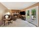Cozy living room with a brick fireplace, neutral carpeting, a desk, and French doors to the backyard at 358 W West Wind Sw Dr, Lilburn, GA 30047