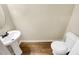 Modern powder room featuring pedestal sink, toilet, and wood-look flooring at 6001 Oak Bend Ct, Riverdale, GA 30296