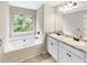 Bathroom featuring double sinks, granite countertops and a soaking tub overlooking a green view at 6001 Oak Bend Ct, Riverdale, GA 30296